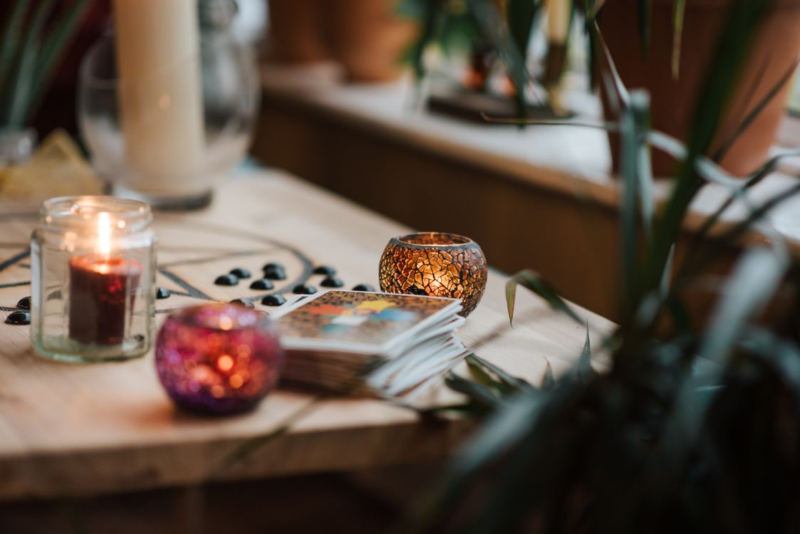 Cartas de tarot junto a velas encendidas sobre un escritorio de madera